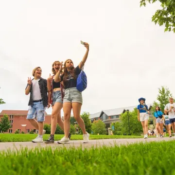 three visiting students taking a selfie on the mall sidewalk 